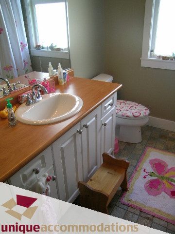 Bright bathroom with wooden countertops and a butterfly-themed rug. - 4330 Canterbury Crescent, North Vancouver