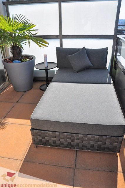Furnished balcony with a comfortable outdoor lounge, potted plant, and sliding glass door. - PH1 - 969 Richards Street, Vancouver Downtown