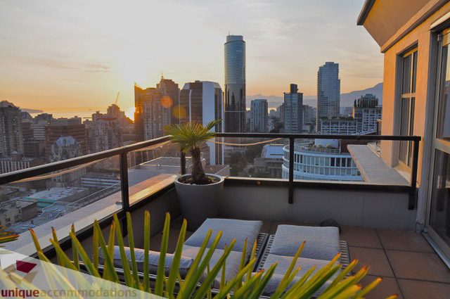 Spacious balcony with stunning city view at sunset, featuring a potted plant and modern furnishings. - PH1 - 969 Richards Street, Vancouver Downtown