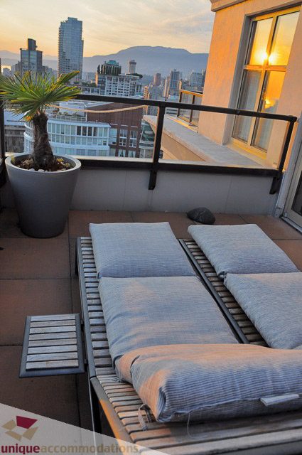 Spacious balcony with lounge chairs and city view at sunset. - PH1 - 969 Richards Street, Vancouver Downtown