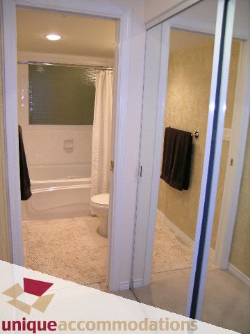 Furnished bathroom with white tiles and a sliding glass door. - 945 Homer Street, Vancouver Downtown