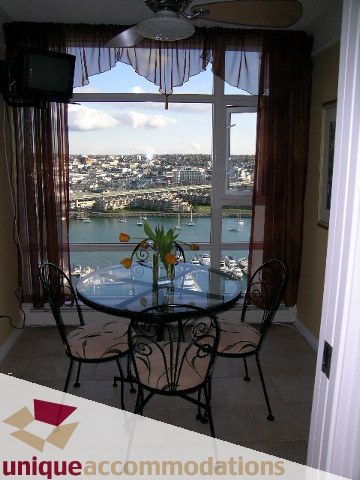 Bright dining area with city view and waterfront, featuring a glass table and patterned chairs. - 2502 - 1199 Marinaside Crescent, Vancouver Downtown