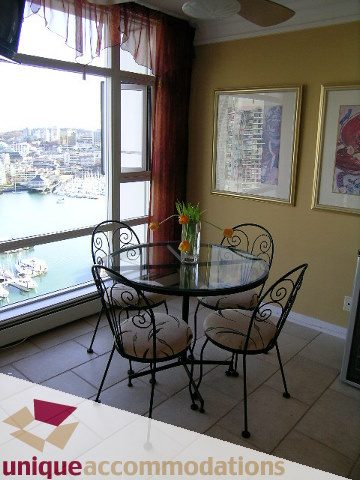 Furnished dining area with city view and wrought iron chairs. - 2502 - 1199 Marinaside Crescent, Vancouver Downtown