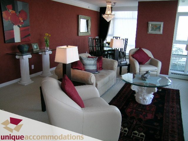 Furnished living room with white furniture, red accents, and a chandelier. - 2502 - 1199 Marinaside Crescent, Vancouver Downtown