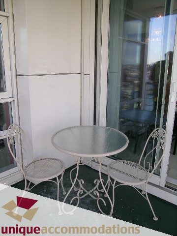 Furnished patio with white metal table and chairs, city view. - 2502 - 1199 Marinaside Crescent, Vancouver Downtown