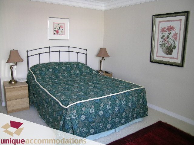 Furnished bedroom with floral bedding and two bedside lamps. - 2502 - 1199 Marinaside Crescent, Vancouver Downtown