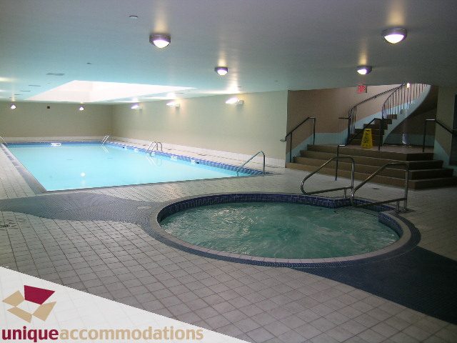 Spacious indoor pool area with tiled floors and stairs leading up. - 2502 - 1199 Marinaside Crescent, Vancouver Downtown
