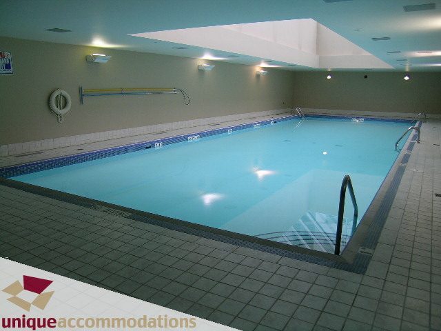 Spacious, well-lit indoor pool area with tiled flooring and skylights. - 2502 - 1199 Marinaside Crescent, Vancouver Downtown
