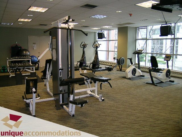 Fitness room with cardio machines and weight equipment, large windows offering a view. - 2502 - 1199 Marinaside Crescent, Vancouver Downtown