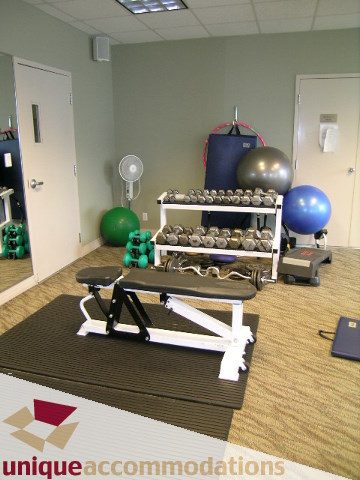 Furnished fitness room with exercise equipment, weights, and yoga balls. - 2502 - 1199 Marinaside Crescent, Vancouver Downtown