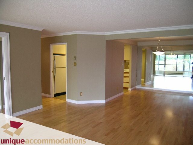 Bright living room with hardwood floors and a view of the kitchen. - 105 - 1490 Pennyfarthing, Vancouver West Side