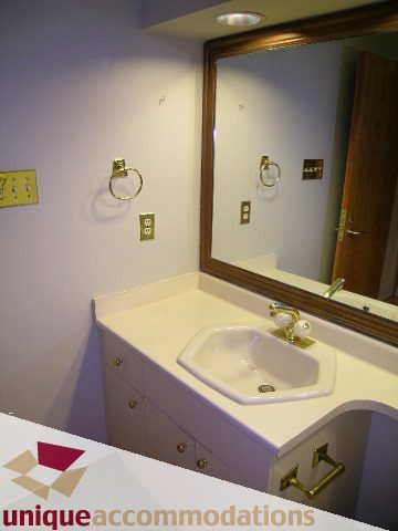 Furnished bathroom with white countertop and gold fixtures. - 105 - 1490 Pennyfarthing, Vancouver West Side