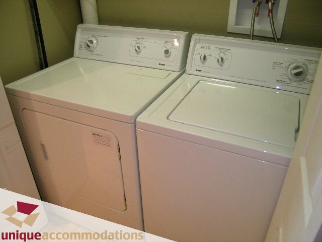 Bright laundry room with white washer and dryer, clean and organized. - 105 - 1490 Pennyfarthing, Vancouver West Side