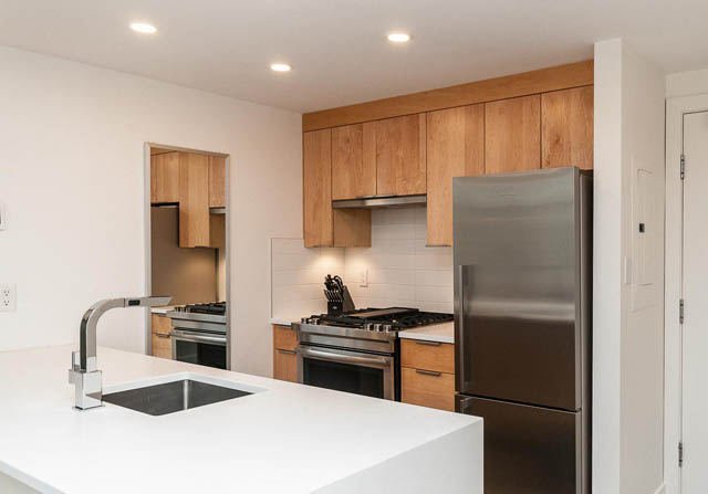 Bright kitchen with white countertops, stainless steel appliances, and wooden cabinets. - 1503 - 198 Aquarius Mews, Vancouver Downtown
