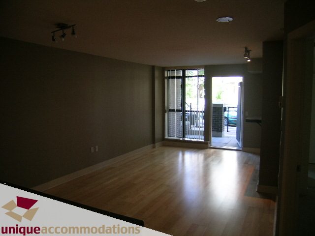 Open-concept living area with hardwood floors and a view of the city. - 104 - 175 W. 1st. Street, North Vancouver