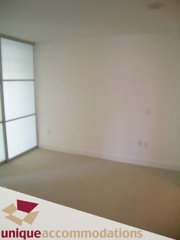 Spacious den with neutral walls and carpeted floor, perfect for a home office or relaxation area. - 104 - 175 W. 1st. Street, North Vancouver