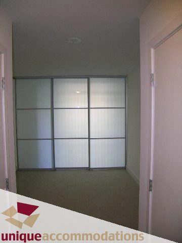 Spacious den with sliding glass doors and neutral carpeting. - 104 - 175 W. 1st. Street, North Vancouver