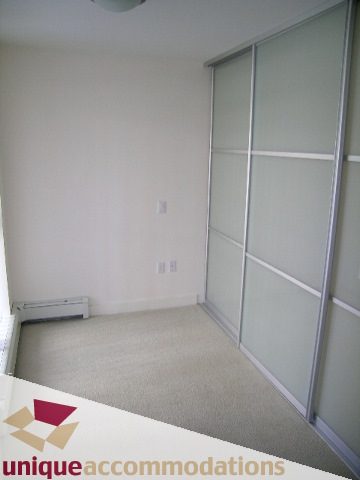 Spacious den with sliding glass doors and neutral carpeting. - 104 - 175 W. 1st. Street, North Vancouver