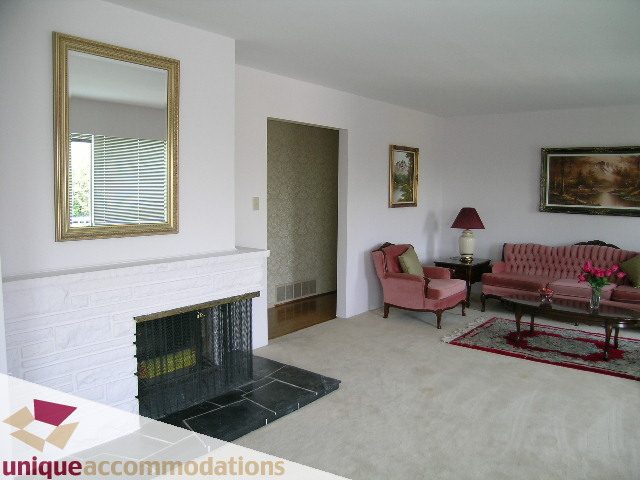 Spacious living room with pink furniture, white walls, and a fireplace. - 94 Bonnymuir Drive, West Vancouver