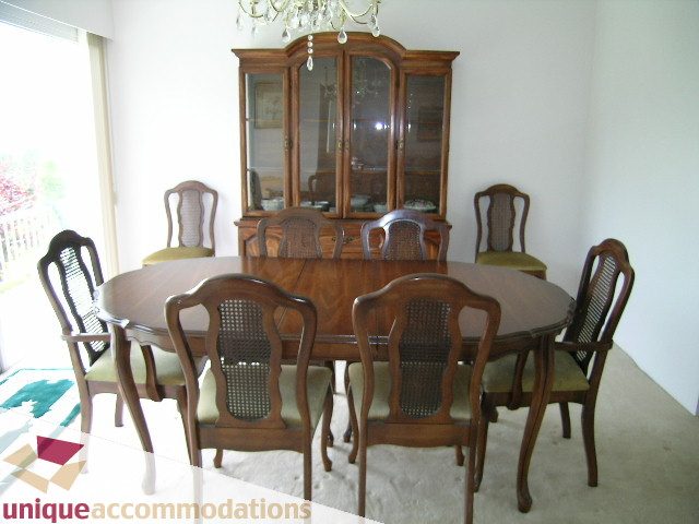 Formal dining room with wooden furniture and glass cabinet. - 94 Bonnymuir Drive, West Vancouver