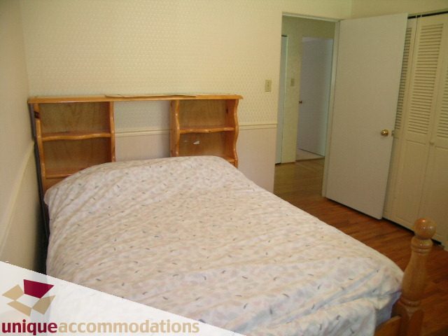 Bright bedroom with twin beds, wooden headboard, and white walls. - 94 Bonnymuir Drive, West Vancouver
