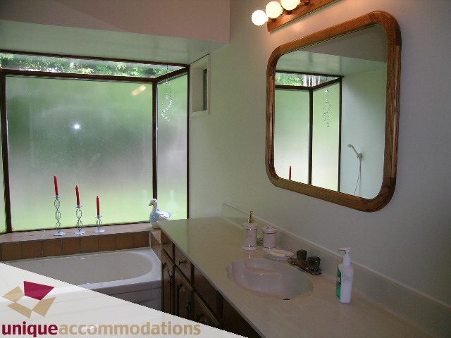 Spacious bathroom with large mirror, frosted windows, and modern sink setup. - 94 Bonnymuir Drive, West Vancouver