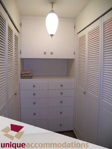Bright laundry room with white cabinets and louvered doors, clean and organized. - 94 Bonnymuir Drive, West Vancouver