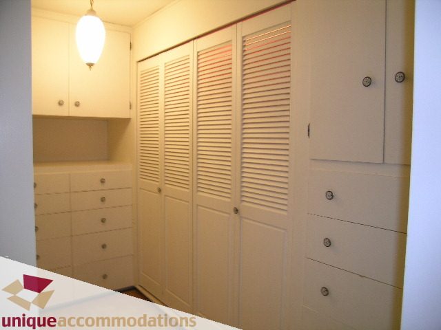 Furnished laundry room with white cabinets and louvered doors. - 94 Bonnymuir Drive, West Vancouver