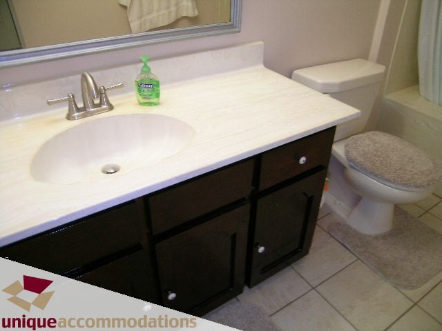 Bathroom with white countertop and black cabinet, tiled floor, and toilet. - 94 Bonnymuir Drive, West Vancouver
