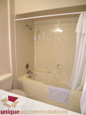 Bathroom with bathtub and shower, white towels neatly hung. - 94 Bonnymuir Drive, West Vancouver