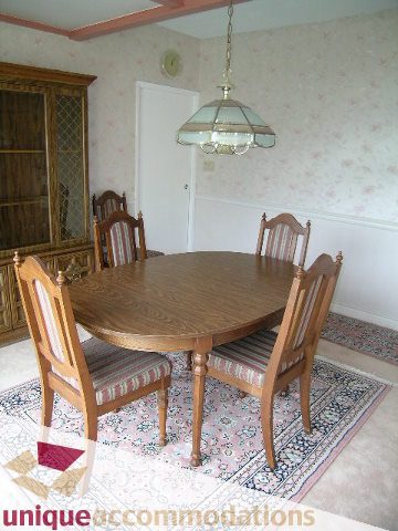 Furnished dining room with wooden table, chairs, and stained glass light fixture. - 94 Bonnymuir Drive, West Vancouver