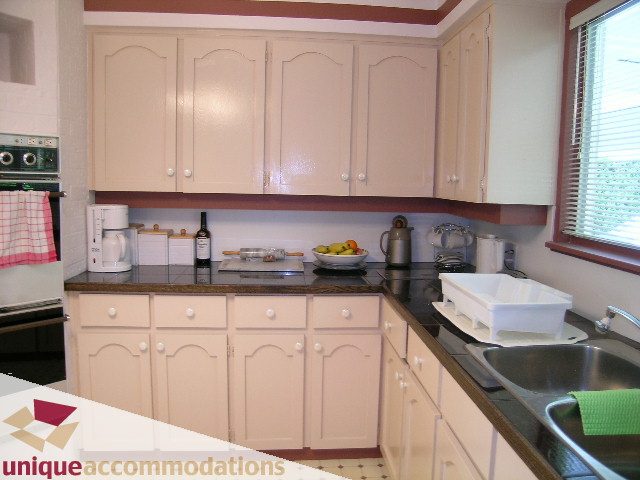 Bright kitchen with cream cabinets, dark countertops, and a window view. - 94 Bonnymuir Drive, West Vancouver
