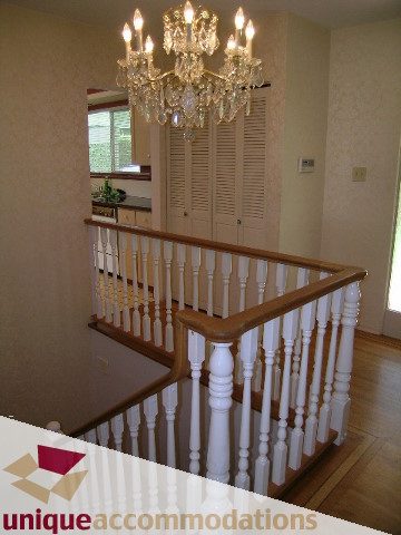 Staircase with ornate chandelier and wooden banister, leading to upper level. - 94 Bonnymuir Drive, West Vancouver