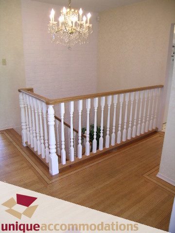 Staircase with white balusters and wooden handrail, leading to upper floor. - 94 Bonnymuir Drive, West Vancouver