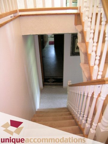 Staircase leading to upper floor with white balusters and carpeted steps. - 94 Bonnymuir Drive, West Vancouver