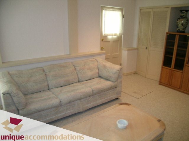 Furnished living room with light-colored couch and wooden coffee table. - 94 Bonnymuir Drive, West Vancouver