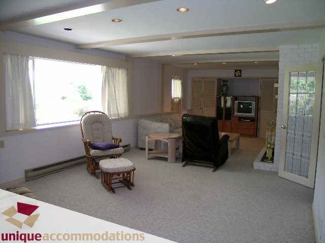 Spacious living room with large windows, cozy seating, and a fireplace. - 94 Bonnymuir Drive, West Vancouver