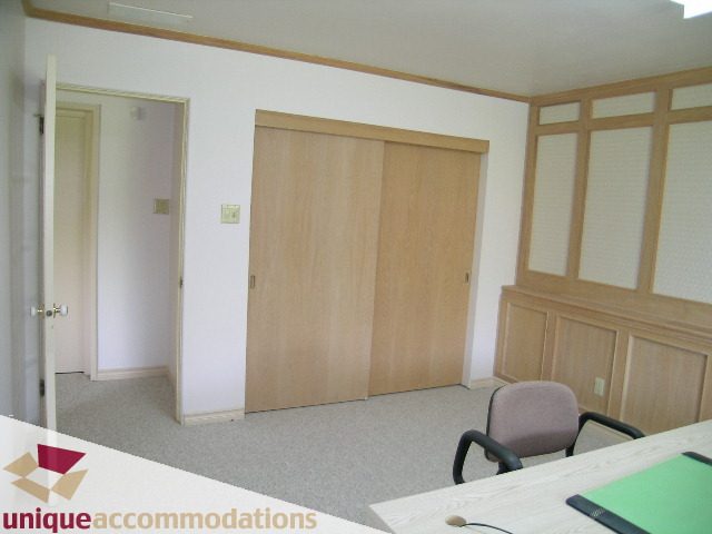 Bright living room with wooden sliding doors and a desk corner. - 94 Bonnymuir Drive, West Vancouver