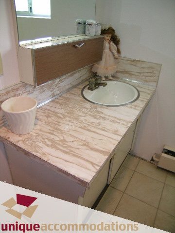 Bathroom with marble countertop and sink, doll on counter. - 94 Bonnymuir Drive, West Vancouver