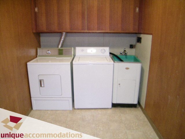 Laundry room with white appliances and teal sink. - 94 Bonnymuir Drive, West Vancouver