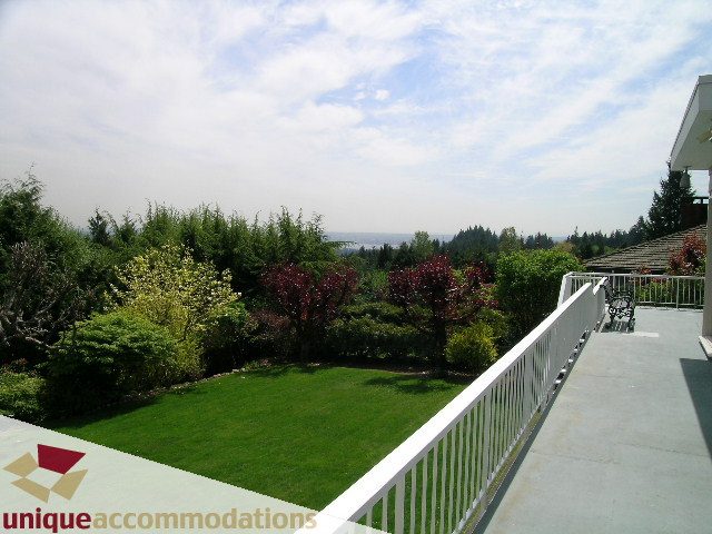 Bright patio with lush green lawn and ocean view. - 94 Bonnymuir Drive, West Vancouver