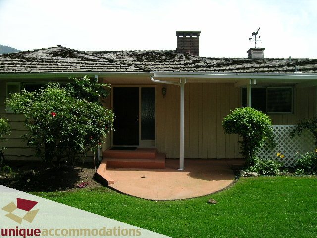 Furnished 3-bedroom house with a cozy front porch and lush green lawn. - 94 Bonnymuir Drive, West Vancouver