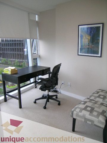 Spacious den with a city view, modern desk setup, and patterned sofa. - 602 - 1233 West Cordova Street, Vancouver Downtown