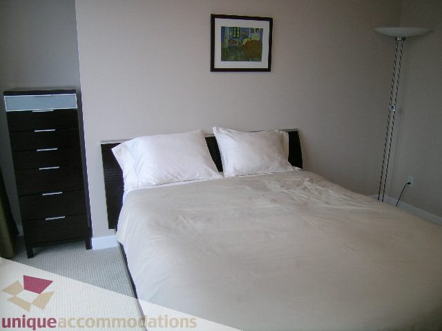 Spacious bedroom with two queen beds, white linens, and a dark wooden dresser. - 602 - 1233 West Cordova Street, Vancouver Downtown