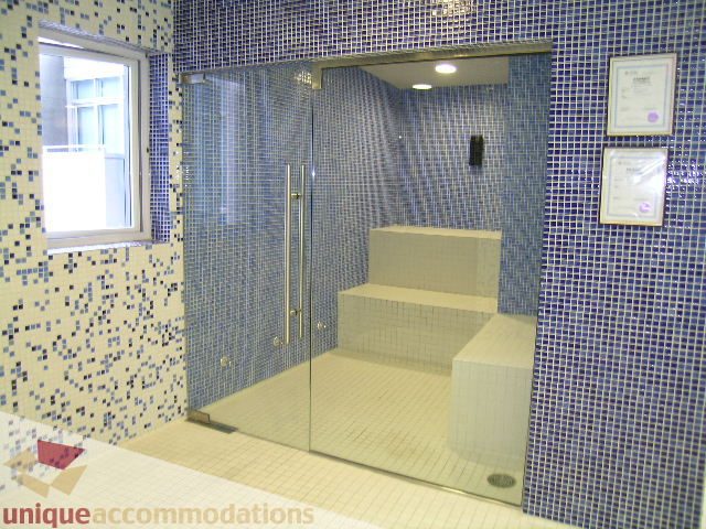 Spacious bathroom with blue mosaic tiles and a large glass shower enclosure. - 602 - 1233 West Cordova Street, Vancouver Downtown