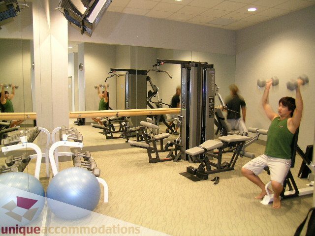 Spacious fitness room with mirrored walls, cardio equipment, and dumbbell racks. - 602 - 1233 West Cordova Street, Vancouver Downtown