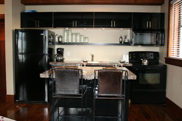 Bright kitchen with black appliances, wooden countertops, and hardwood floors. - 30 - 777 Burrard Street, Vancouver Downtown