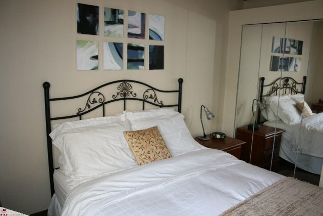 Furnished 1-bedroom with white bedding and decorative wall art. - 30 - 777 Burrard Street, Vancouver Downtown