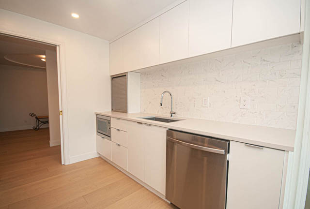 Bright kitchen with white cabinets, marble backsplash, and hardwood floors. - 1901 - 909 Burrard Street, Vancouver Downtown