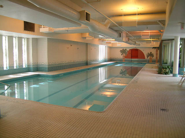 Spacious, well-lit indoor pool area with tiled walls and ceiling, modern design. - 1901 - 909 Burrard Street, Vancouver Downtown
